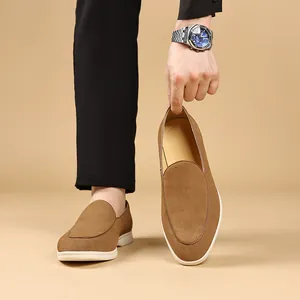 Detailopname van bruine suède herenloafers met een witte flexibele rubberen zool