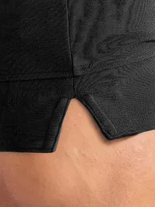 Dettaglio ravvicinato dello spacco laterale su pantaloncini sportivi neri traspiranti