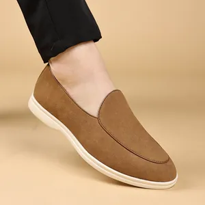 Close-up zijaanzicht van comfortabele bruine suède heren loafers met een witte flexibele zool.