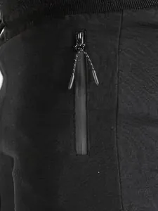 Dettaglio ravvicinato della tasca verticale con zip su pantaloncini sportivi neri da corsa