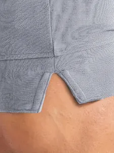 Dettaglio ravvicinato dello spacco laterale su questi pantaloncini sportivi grigi