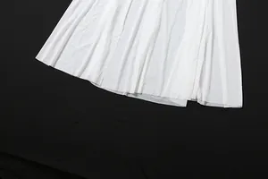Detail shot of white pleated mesh sheer skirt fabric texture on black background