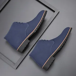 Side view of navy blue suede men's Martin boots with pointed toe on a gray background