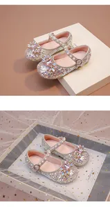 Détail de chaussures de princesse pour fille avec paillettes, fleur rose et perles