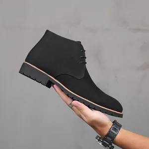 Close-up detail of men's black suede desert boot featuring a lace-up design and thick lug sole.