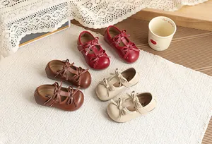 Detail view of girls bow princess Mary Jane shoes in red brown and beige colors