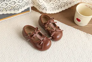 Detailed view of vintage brown toddler leather shoes featuring elegant double bow design