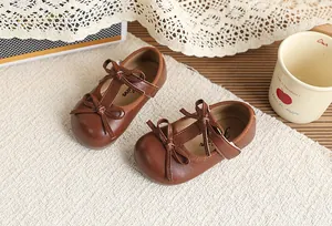 Close-up of brown toddler girl Mary Janes with elegant bowknots and Velcro strap