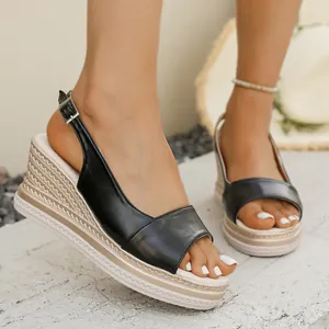 Dettaglio di sandali con zeppa neri da donna con plateau intrecciato e fibbia
