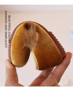 Detailopname van een flexibele mosterdgele fluwelen prinsessenschoen voor meisjes met een pompon