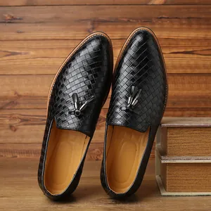 Detailed view of black woven leather loafers with decorative tassels and slip-on design