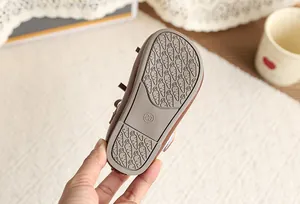 Detail view of non-slip rubber sole with carrot pattern on toddler girl's leather shoe