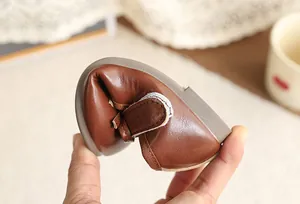 Detailed view of the flexible soft sole and quality leather of brown girl's dress shoes