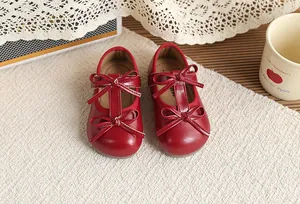 Red girl's Mary Jane shoes with double bow accents and a vintage British style design