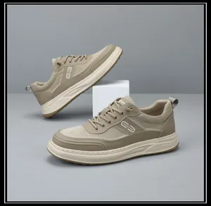 Detailed view of men's beige thick-soled sneakers with patchwork design on grey background