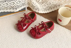 Close-up view of red girls' Mary Jane shoes with elegant bow detailing in a lifestyle setting