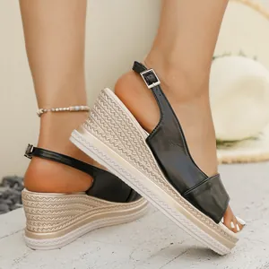 Vista dettagliata di sandali neri con zeppa da donna con suola platform in corda intrecciata.
