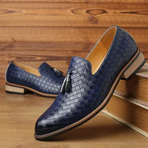 Detail showing the premium woven texture and black tassels on blue leather loafers