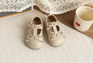 Elegant beige toddler girls Mary Jane princess shoes with double bow accents on white rug