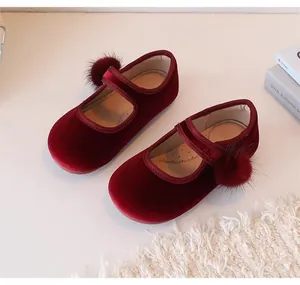 Gedetailleerd overzicht van bordeauxrode fluwelen Mary Janes met pompon