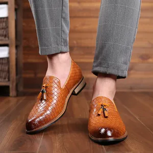 Macro detail of men's tan woven loafers featuring tassel accent and glossy gradient toe