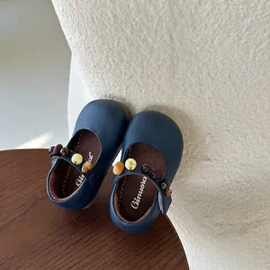Detailopname van donkerblauwe Mary Jane kinderschoenen met decoratieve kralenbandjes
