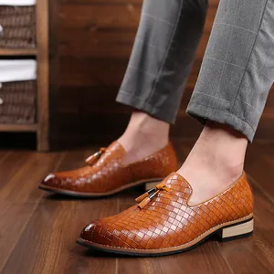 Detailed view of men's brown loafers featuring woven texture and decorative tassels