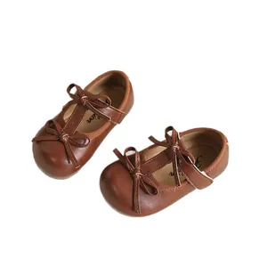 Classic brown girls' Mary Jane shoes with double bows and T-strap design.