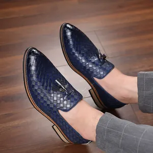 Detailed shot of blue woven leather loafers with tassel accents on wooden flooring
