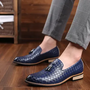Close-up of stylish blue woven leather loafers with decorative tassels worn by a model