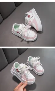 Détail de baskets roses pour filles avec nœud en ruban et logo de personnage
