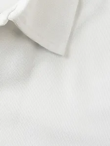 Gros plan sur la texture gaufrée blanche du col d'un polo pour homme