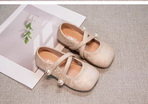 Close-up detail of girl's traditional Hanfu shoes featuring pearl cross-straps and floral embroidery