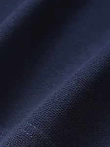 Gros plan macro montrant la texture du tissu en maille gaufre bleu marine d'un polo