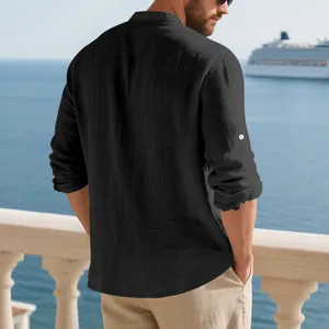 Back view of a man wearing a black linen casual shirt with a stand-up collar on a balcony