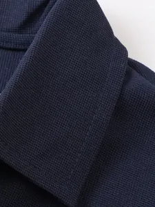Détail macro montrant la texture en maille gaufrée bleu marine d'un col de polo pour hommes