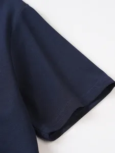 Gros plan détaillé sur la texture gaufrée bleu marine de la manche du polo homme