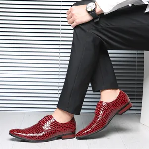 Close-up of men's red glossy stone pattern pointed-toe leather dress shoes on feet