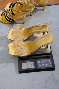 Misurazione del peso di sandali dorati a punta quadrata con fiocchi di strass