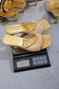 Sabot dorati con tacco alto che pesano 401,1 g su una bilancia elettronica.