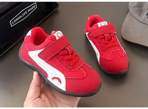Dettaglio di sneaker per bambini in mesh rosso traspirante con striscia bianca.
