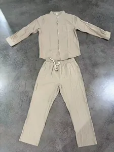 Detailed flat-lay view of men's beige linen set with stand-collar shirt and long pants