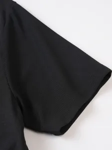 Gros plan de la manche d'un polo noir en maille gaufrée avec texture