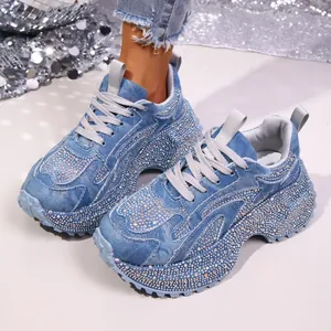Detailansicht von stilvollen hellblauen Denim-Plateau-Sneakern mit schimmernden Strasssteinen
