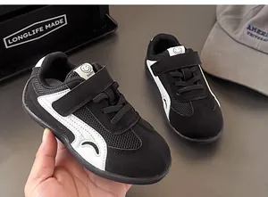 Dettaglio di sneaker traspiranti in mesh per bambini in bianco e nero con chiusura a velcro