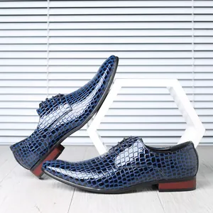Close-up detail of blue shiny stone pattern men's pointed leather shoes on white background