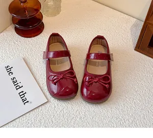 Close-up view of red patent leather Mary Jane shoes for girls with a cute bow detail