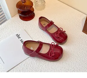 Detailed view of girls' dark red patent leather Mary Jane shoes with cute bow