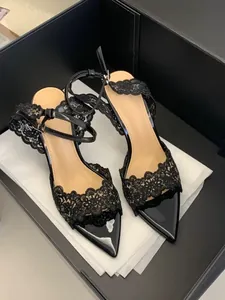 Detailed macro shot of black lace embroidery on elegant pointed-toe high-heeled sandals.