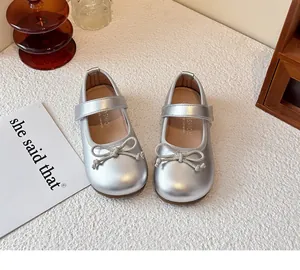 Close-up view of elegant silver girls' leather princess shoes with cute bow design